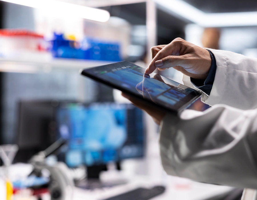 Científico utilizando una tableta digital en un laboratorio científico para analizar datos de ensayos moleculares y pruebas científicas.